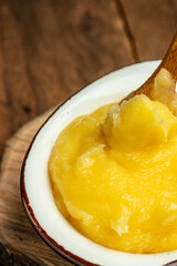 Homemade ghee Pure desi ghee in a bowl with wooden spoon, Healthy fats, clean eating for weight loss. place for text, top view