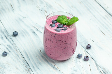 blueberry smoothie in glass on a light background. Delicious balanced food concept. top view