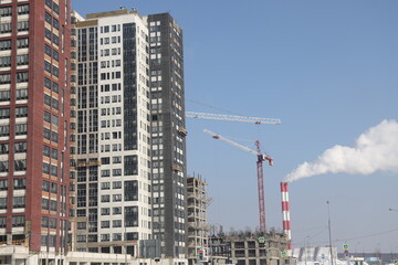 Fototapeta na wymiar Construction site background. Hoisting cranes and new multi-storey buildings. I.ndustrial background.