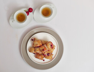 The buns are sweet and rich. Cups of tea on a white background. View from above.