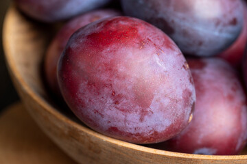 Ripe plums of dark color on the table