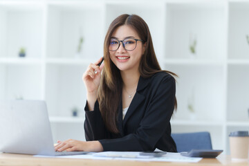 Attractive asia busy business woman consultant auditor working at modern office with balance sheet accounting bookkeeping documents. Account verification to prevent fraud bribery.