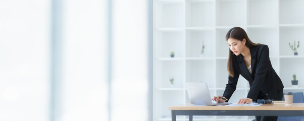 Attractive asia busy business woman consultant auditor working at modern office with balance sheet accounting bookkeeping documents. Account verification to prevent fraud bribery.