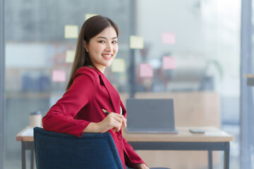 Attractive asia busy business woman consultant auditor working at modern office with balance sheet...