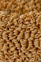 dried Instant noodles on white mulberry paper background. Instant noodles and pasta are wheat flour products call junk convenience food. Chinese and Japanese oriental noodle.