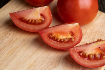 sliced red ripe tomato on a board