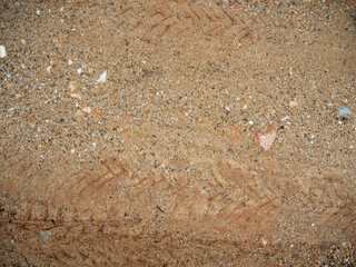 imagen detalle textura suelo de tierra con marcas de ruedras de coche y piedras 