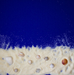 frame made of sand, shells and snail shells on a dark blue background on which to write or present something, top view