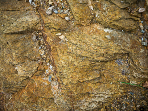imagen detalle textura suelo de piedra amarillenta con pequeñas piedras de otros colores en las grietas 
