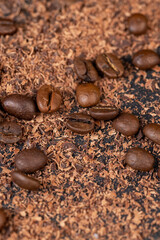Roasted coffee beans lie together with chocolate crumbled into small pieces