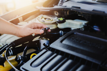 close up of man hand holding cap engine  oil  tank  while checking oil level in a engine , check...