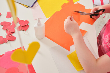 children's applications for valentine's day, the girl cuts out valentines and makes cards for the holiday
