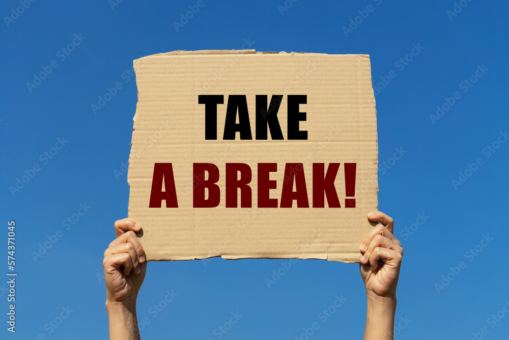 Wall mural take a break text on box paper held by 2 hands with isolated blue sky background. this message board