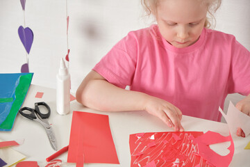 children's applications for valentine's day, the girl cuts out valentines and makes cards for the holiday