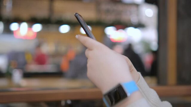 Beautiful girl in the mall. Surfing the Internet, reading messages on a woman's hand in a smart watch. Modern lifestyle concept 4K