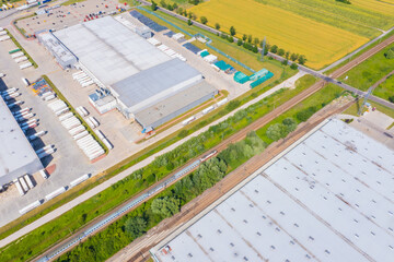 Aerial view of goods warehouse. Logistics center in industrial city zone from above. Aerial view of trucks loading at logistic center stock photo