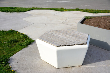white hexagon bench isolated on concrete pathway in public park, close-up