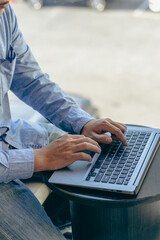 Hand of young contemporary office manager pressing laptop keyboard during working Successful male programmer working software for program vertical image