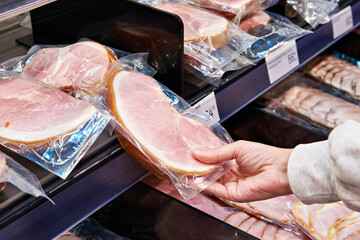 Hands with ham at store