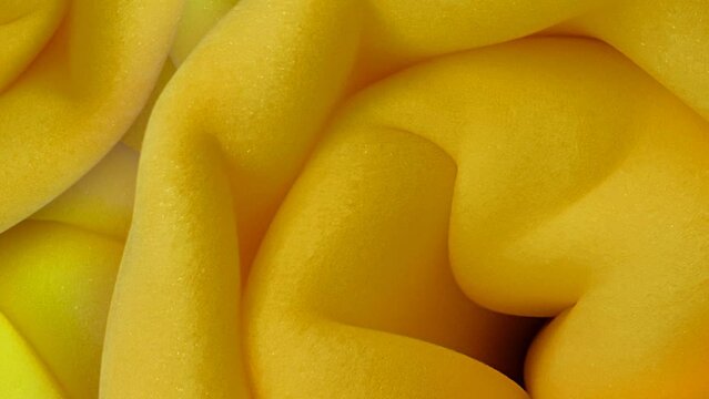 pile of thick yellow and orange foam sponges. circular bundle. textured sofa material. rolled or prepackaged polyurethane