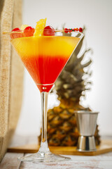 Bikini martini cocktail in martini glass garnished with cherries and pineapple. Martini alcoholic cocktail or non-alcoholic mocktail. Martinis.