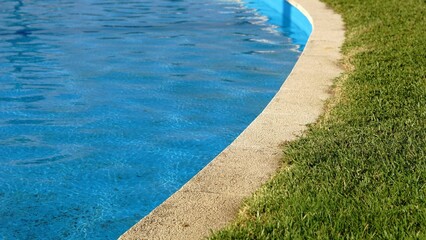 edge of a pool with grass floor