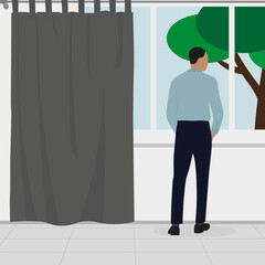 Fototapeta premium A man in business clothes stands and looks out the window