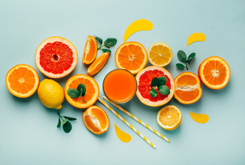 top view of orange grapefour and lemon citrus fruits with juice and herbs on blue background