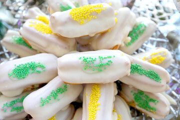 Close up of white chocolate eclairs decorated with small colored candies.