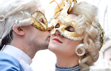 Couple kissing and dressed up for the Venice Carnival wearting contemporary clothes