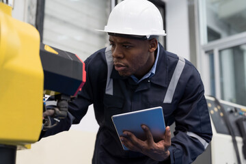 African American male engineer worker or electrician using tablet for checking or maintenance...