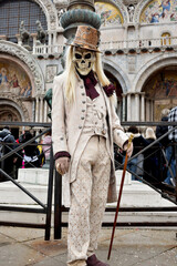 Obraz premium Person dressed up for Carnival of Venice wearing skull mask and white suit