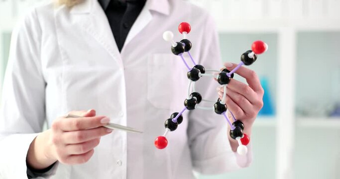 Woman scientist shows model of molecular structure in hands