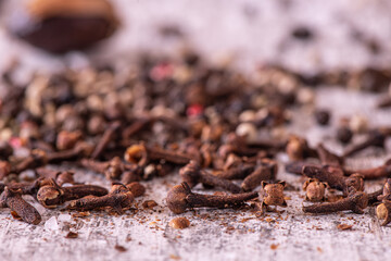 Cloves and pepper on a wooden table