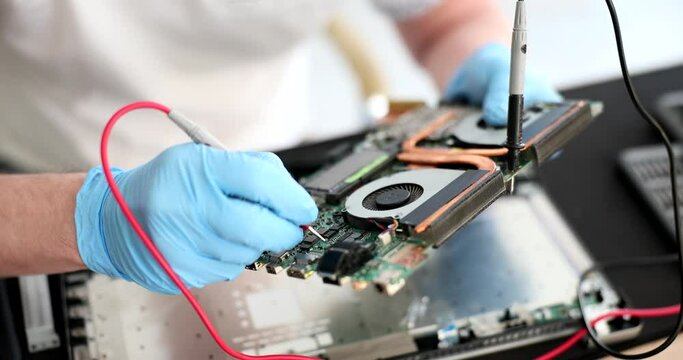 Technician with millimeters at workplace with and computer printed circuit board