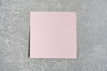 Fototapeta premium Pink paper sticker for writing notes is pasted concrete wall.