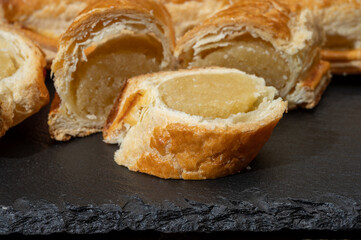 Fresh baked Dutch filled spicy cookies from puff pastry with almonds in autumn colors on dark stone
