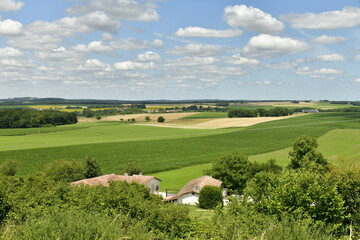 Fototapeta na wymiar L'un des hameaux en contrebas du puy de Versac devant l'immensité des champs d'agriculture au Périgord Vert 