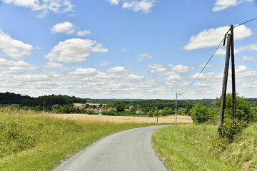 Route secondaire de campagne entre les végétation et champs de blé près du Puy de Versac au...