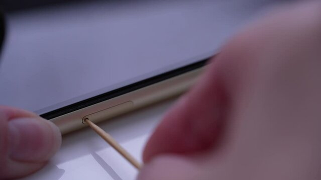 Person inserting a sim card into back of mobile phone, Sim card in tray being inserted into phone
