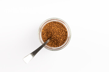 Soluble coffee grains in a glass jar isolated on a white background.