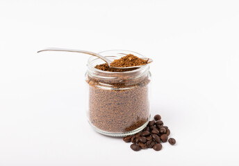 Soluble coffee grains in a glass jar isolated on a white background.