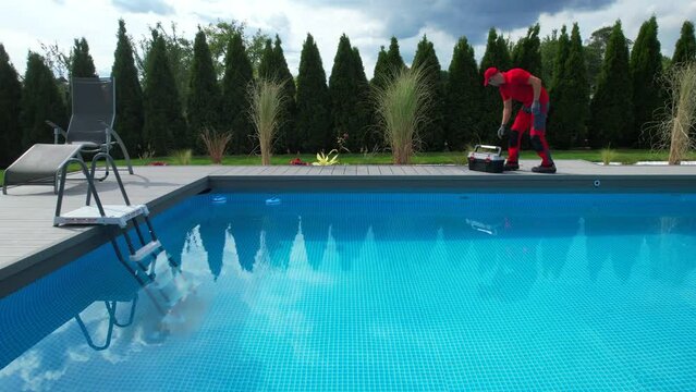 Outdoor Residential Swimming Pool Maintenance. Technician Walking Along the Poolside.