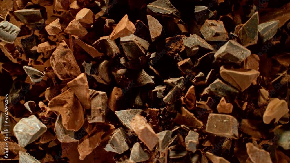Poster super slow motion of rotating group of raw chocolate pieces. super fast camera motion. filmed on hig
