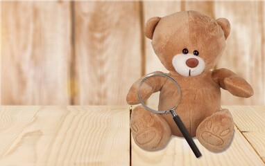 Cute toy bear hold a magnifying glass