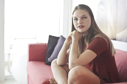young woman sitting on sofa at home