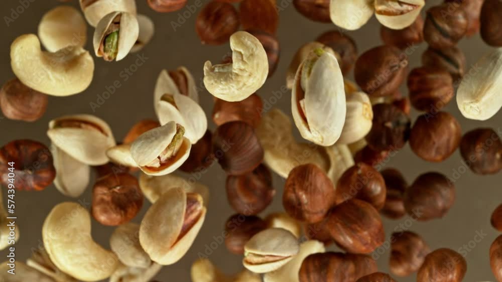 Poster super slow motion of rotating mix nuts up to the air. filmed on high speed cinema camera, 1000fps, p