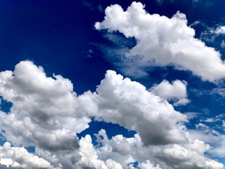 Piece of indigo blue sky during the day with white clouds in summer day