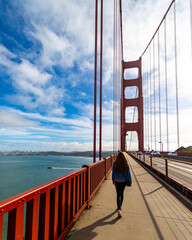 long hair girl in denim jacket walking through the golden gate bridge in san francisco, californa,...