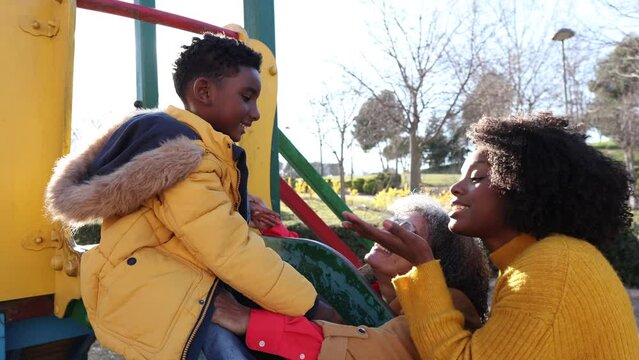 grandmother mom and grandson playing in the slide park - single mother, african american family -